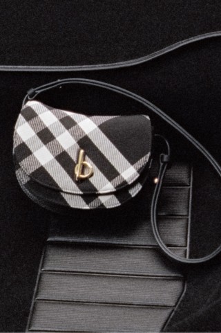 Vídeo exibindo a bolsa Rocking Horse em preto, com detalhes em xadrez creme e dourado na frente da satchel.