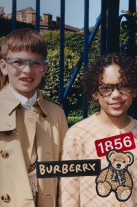 バーバリー チルドレンズ新着でバーバリートレンチコートを着た男の子のモデルとバーバリーチェック ニットウェアを着た女の子のモデル。