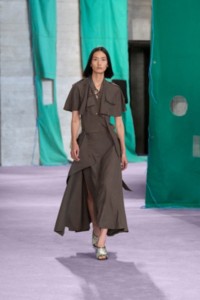 Model wearing silk trench dress in cellar.