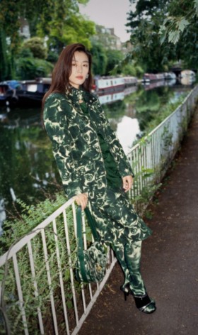 Model wears Rose print waxed cotton field jacket in ivy