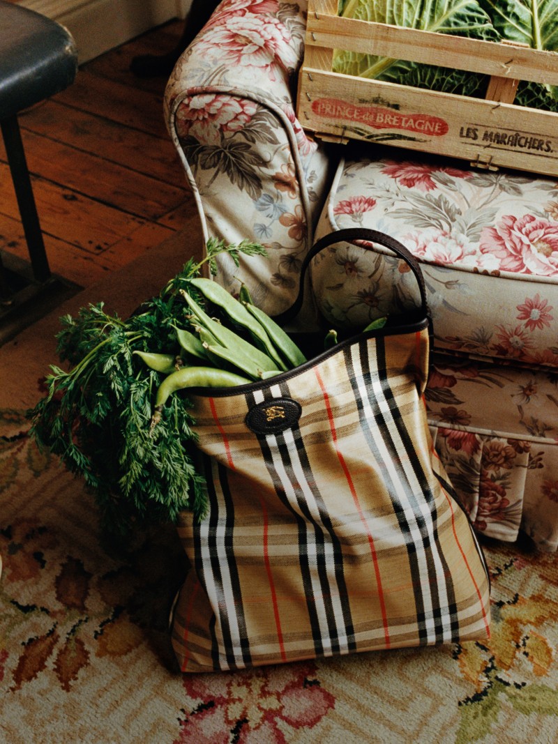 Shot of Highlands Shoulder Bag in colour Sand against an armchair