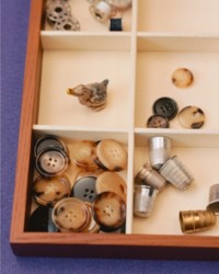 Shot of box with compartments holding, buttons and thimbles 