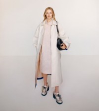 Model in einem Car Coat und einem Kleid aus Viskose mit Rosenmuster in der Farbe Cameo sowie Pumps „Stride“ aus Leder in Pythonleder-Optik in der Farbe Serpent.