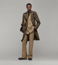 Modelo usando um trench coat com um paletó com abotoamento trespassado e calças de alfaiataria de lã