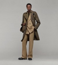 Model in Trenchcoat, zweireihigem Jackett und eleganter Wollhose