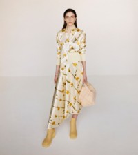 Model wearing the Dandelion print shirt and skirt in sherbet, paired with the Check knitted Peg bag and Marsh boots in cream.