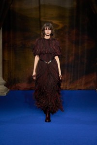 Lucy Fletcher wearing shredded viscose dress in brown, orange and black and leather cavalier boots in mahogany red.