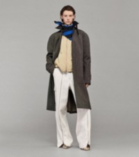 Modelo usando um casaco xadrez com uma jaqueta com capuz, calças com detalhes de zíper, scarpins xadrez Burberry Check e um lenço listrado em Knight