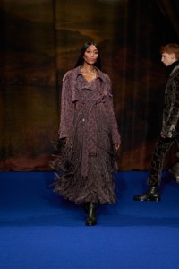 Naomi Campbell wearing baroque damask trench coat, jodphur trousers and boots