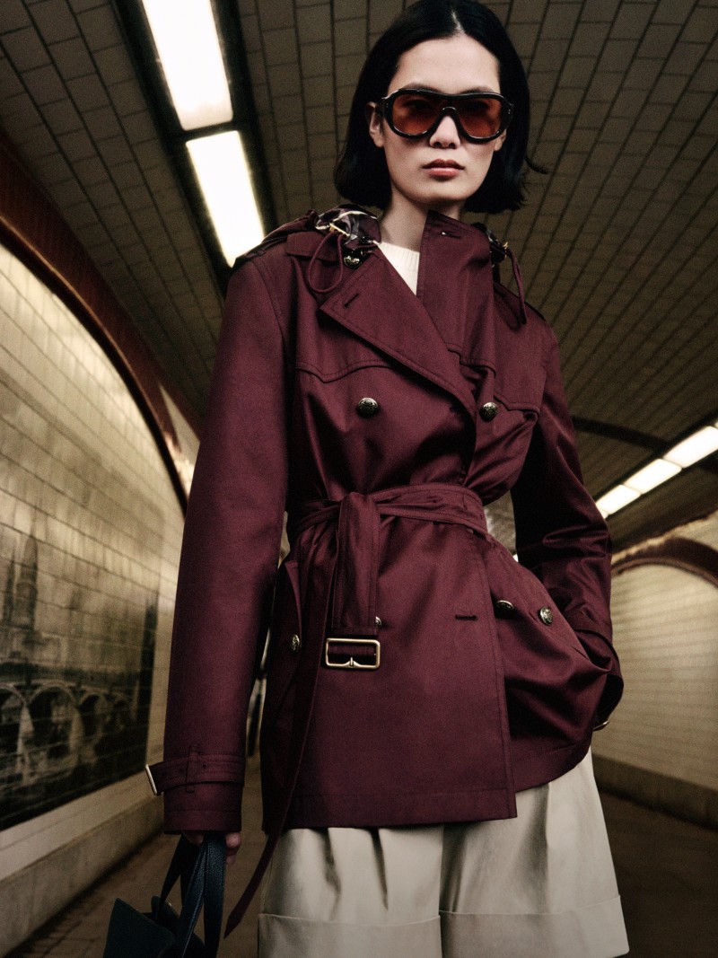 Shot of model wearing the Short Tropical Gabardine Foxfield Trench Coat in colour Vineyard red with some Belted Tropical Gabardine Shorts in colour Saltmarsh beige
