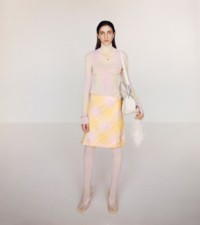 Model wearing the Argyle cotton silk ribbed turtleneck and jacquard kilt in cameo and sherbet.