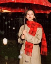 A atriz chinesa Zhang Jingyi usa um trench coat Burberry com um cachecol xadrez Burberry Check vermelho