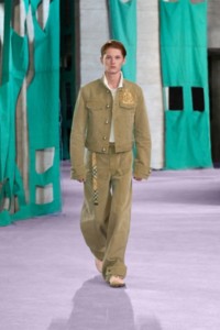 Model in Jacke aus Baumwollcanvas und Cargohose in der Farbe Walrus sowie Poloshirt aus Baumwollpiqué in der Farbe Salt mit gesticktem Equestrian Knight Design