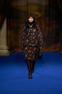 Anugraha Natarajan wearing ditsy print jacket and skirt in crimson red, paired with leather black bag and Silver enamel Star Bow necklace and Gold-plated Shield Segment ring.